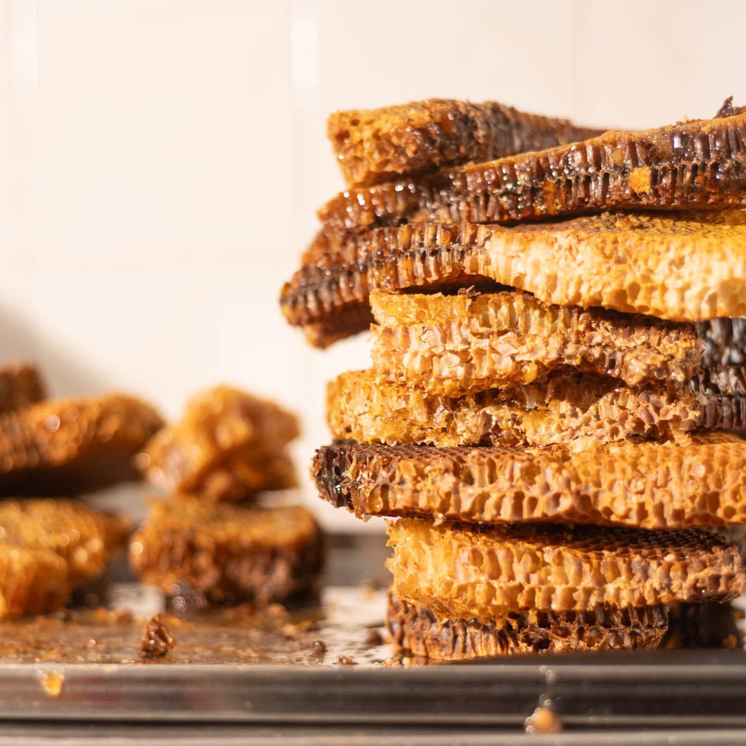 Auf einem Edelstahlblech verschiedenfarbige Demeter-Honigwaben im Naturwabenbau übereinander gestapelt